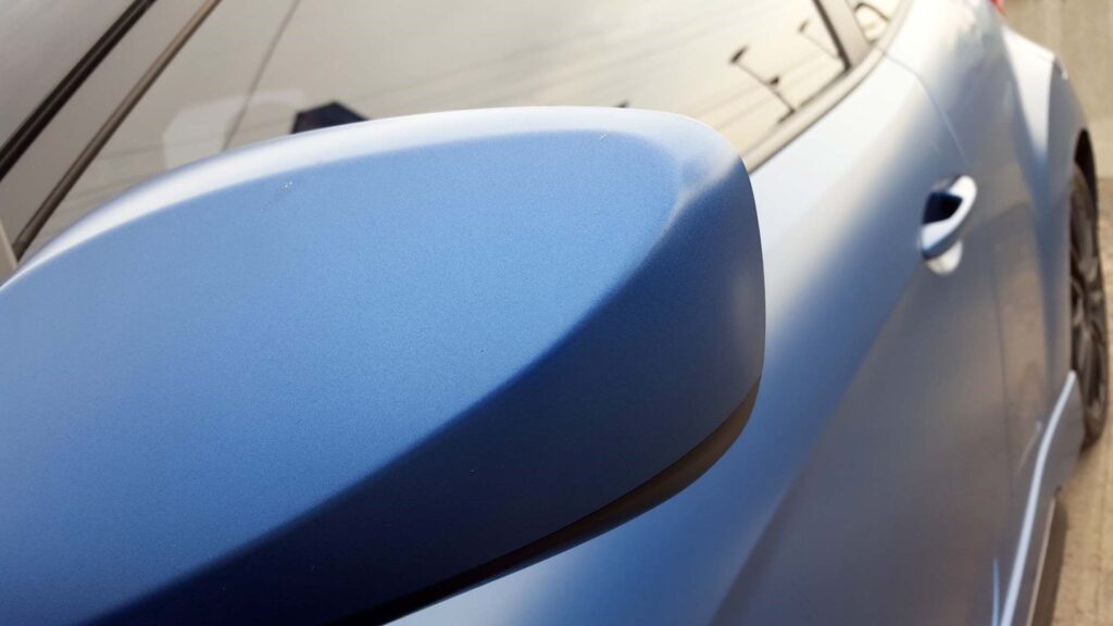 close up picture of a blue matte color car
